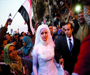   مصر اليوم - عروسان يحتفلان بزفافهما في ميدان التحرير وسط المعتصمين وقنابل الغاز