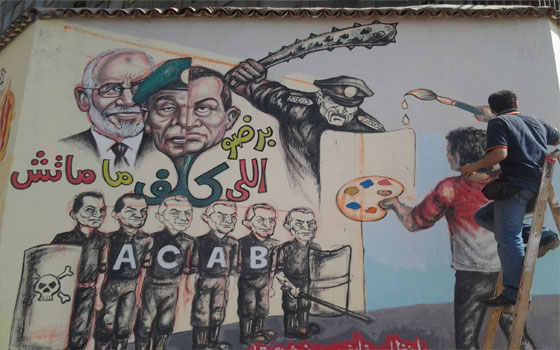 مصر اليوم - معركة بـالبوسترات والجرافتي بين الإخوان والثوار في شوارع السويس