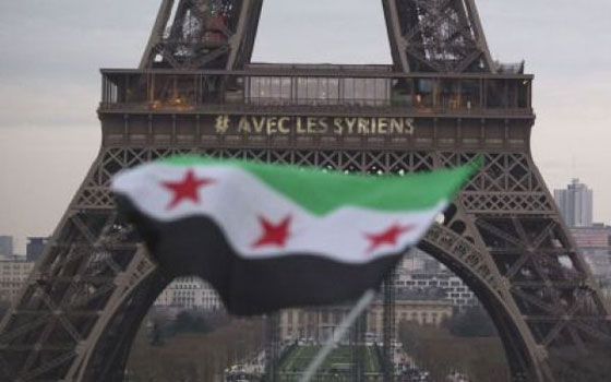   مصر اليوم - برج إيفل في وسط باريس يُضاء بالشموع ليلاً ويحتضن علم الثورة السوريَّة