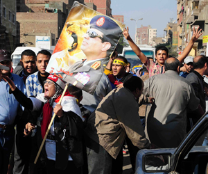   مصر اليوم - أنصار السيسي يغطون شوارع سوهاج باسمه وصوره