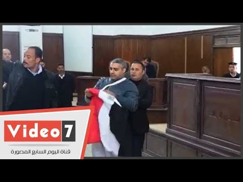 صحافي الجزيرة يرفع علم مصر أثناء محاكمته