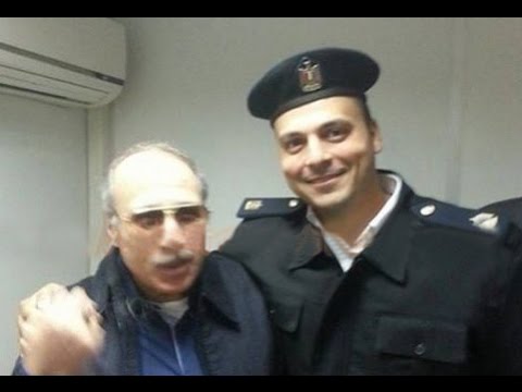 العادلي يلتقط صورة سيلفي مع الضابط المكلف بحراسته