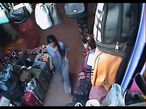امرأة تسرق شنطة من أمام محل للحقائب