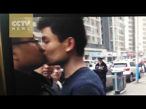 صيني يقبل ضابط شرطة أثناء إزالة مطعمه المخالف
