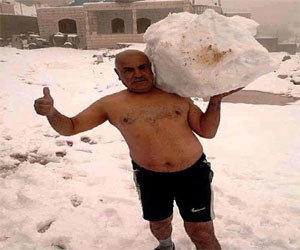   مصر اليوم - فلسطيني يرفع أثقالاً من الثلج وهو شبه عار